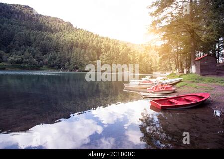 Rot-weiße Boote auf mexikanischem See in den Bergen Bei Sonnenaufgang Stockfoto