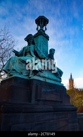 Glasgow/Schottland-13. Nov 2013: Herbst in der Stadt. Grüne Bronzestatue auf Kelvin Way Brücke. University of Glasgow Turm im Hintergrund. Gelbe Bäume