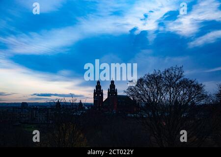 Glasgow/Schottland - 13. Nov 2013: Silhouette der Kelvingrove Art Gallery und Museum und eines Baumes. Blauer Himmel mit Wolken. Kalte Tage im Herbst oder Winter. Stockfoto