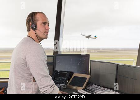 Der Mann im Headset schaut weg, während er als Flight Dispatcher arbeitet Am Flughafen Stockfoto