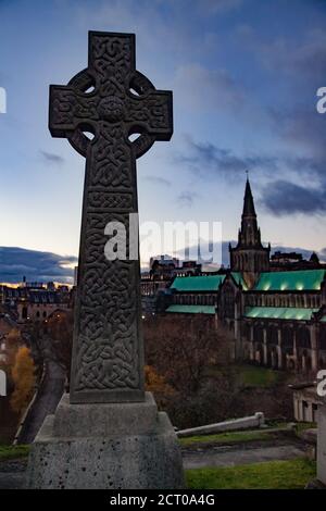 Glasgow / Schottland - 13. Nov 2013: Glasgow Necropolis. Fallen Sie in die Stadt. Grabmal mit keltischem Kreuz. Glasgow Cathedral verschwommen im Hintergrund. Stockfoto