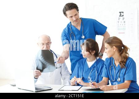 Gruppe von Ärzten und Krankenschwestern, die Röntgenaufnahmen betrachten Büro Stockfoto