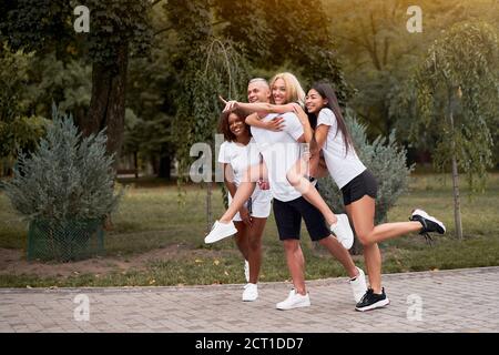 Multiethnische Gruppe Teenager Freunde. afroamerikanisch asiatisch kaukasisch Student verbringen Zeit zusammen Piggy Rücken Fahrten mit Spaß multirassische Freundschaft Stockfoto