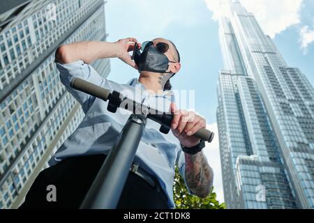 Mann auf dem Roller ruft am Telefon Stockfoto