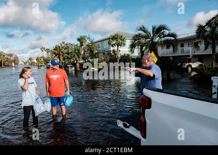 Orange Beach, ALABAMA, USA. September 2019. (Von links nach rechts) Brent McCoy und seine Tochter Lucy erhalten am 16. September 2020 in Orange Beach, Alabama, USA, Eissäcke von Chuck Anderson in einer vom Hurrikan Sally überfluteten Nachbarschaft. Hurrikan Sally landtete am Morgen als Kategorie-2-Hurrikan. Quelle: Dan Anderson/ZUMA Wire/Alamy Live News Stockfoto