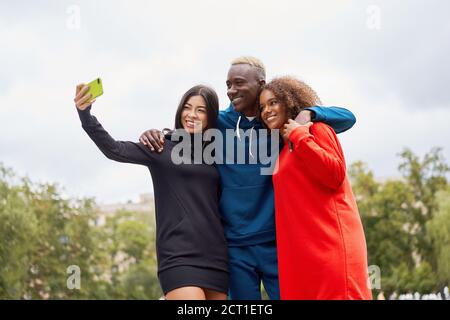 Multiethnische Freunde im Freien nehmen ein Selfie auf dem Smartphone. Diverse Gruppe Menschen Afro american Asian verbringen Zeit zusammen multirassischen männlichen weiblichen st Stockfoto