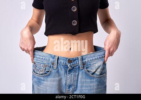 Schlanke Mädchen trägt übergroße Denim-Hose. Stockfoto