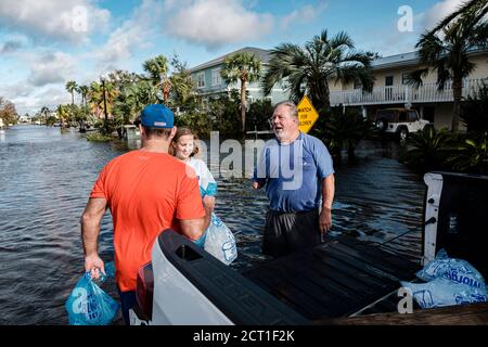 Orange Beach, ALABAMA, USA. September 2019. (Von links nach rechts) Brent McCoy und seine Tochter Lucy erhalten am 16. September 2020 in Orange Beach, Alabama, USA, Eissäcke von Chuck Anderson in einer vom Hurrikan Sally überfluteten Nachbarschaft. Hurrikan Sally landtete am Morgen als Kategorie-2-Hurrikan. Quelle: Dan Anderson/ZUMA Wire/Alamy Live News Stockfoto