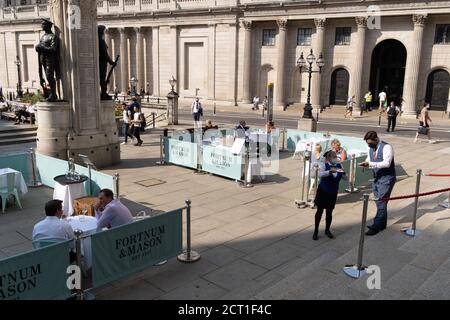 Diners und Trinker sitzen auf Straßensperren, wo Fortnum & Mason während der Coronavirus-Pandemie am 9. September 2020 in London, England, ein Restaurant und eine Bar im Freien vor der Royal Exchange at Bank in der City of London eingerichtet haben. Stockfoto