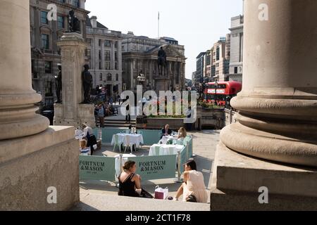 Diners und Trinker sitzen auf Straßensperren, wo Fortnum & Mason während der Coronavirus-Pandemie am 9. September 2020 in London, England, ein Restaurant und eine Bar im Freien vor der Royal Exchange at Bank in der City of London eingerichtet haben. Stockfoto