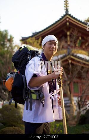 Junger japanischer Pilger (Henro) mit ritueller Ausrüstung (weißes Hemd, Holzstab) auf der Shikoku Pilgerfahrt von 88 Tempeln, Japan 2012. Stockfoto