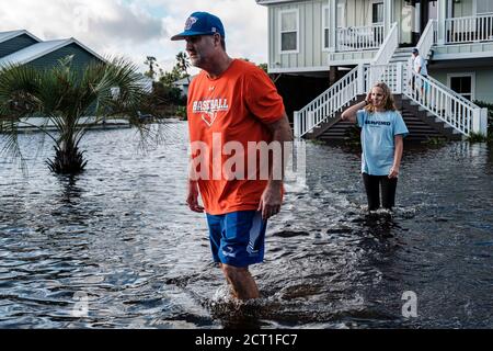 Orange Beach, ALABAMA, USA. September 2019. (Von links nach rechts) Brent McCoy und seine Tochter Lucy gehen am 16. September 2020 in Orange Beach, Alabama, USA, durch ein vom Hurrikan Sally überflutetes Viertel. Hurrikan Sally landtete am Morgen als Kategorie-2-Hurrikan. Quelle: Dan Anderson/ZUMA Wire/Alamy Live News Stockfoto