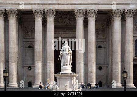 Die Besucher ruhen auf den Stufen der St. Paul's Cathedral mit der Statue der Königin Anne auf dem Vorplatz dieses berühmten Londoner Wahrzeichen am 16. September 2020 in London, England. Die Statue ist eine Kopie einer Skulptur von Francis Bird aus Carrara-Marmor aus dem Jahr 1712, die früher an derselben Stelle stand. Königin Anne war die regierende britische Monarchin, als die neue St. Paul's Cathedral 1710 fertiggestellt wurde. Stockfoto