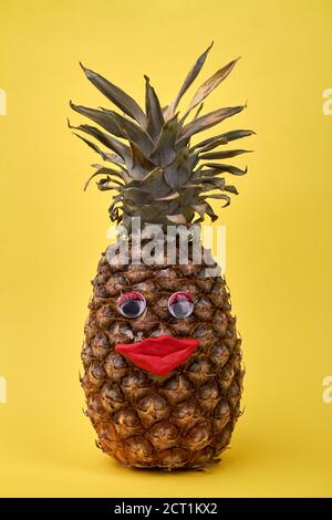 Ananas mit lustigen Augen und roten Lippen. Stockfoto