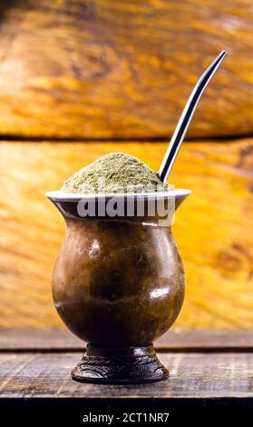 Mate Tee in Holzschale auf Holztisch. Traditionelles Getränk aus Brasilien, Argentinien, Paraguay und Südamerika. Stockfoto