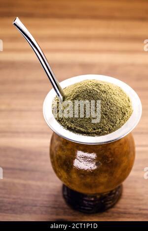 Gaucho Yerba Mate Tee, der chimarão, typisch brasilianisches Getränk, traditionell in einer Cuiade Bombilla Stick Kürbis vor Holzgrund. Rio Grande do Stockfoto