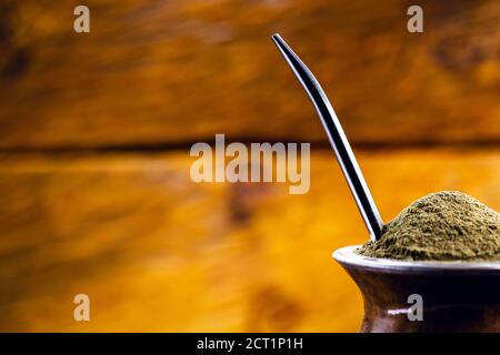 Gaucho Yerba Mate Tee, der chimarão, typisch brasilianisches Getränk, traditionell in einer Cuiade Bombilla Stick Kürbis vor Holzgrund. Rio Grande do Stockfoto