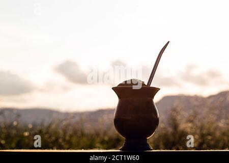 Gaucho Yerba Mate Tee, der chimarão, typisch brasilianisches Getränk, traditionell in einer Cuiade Bombilla Stick Kürbis vor Holzgrund. Rio Grande do Stockfoto