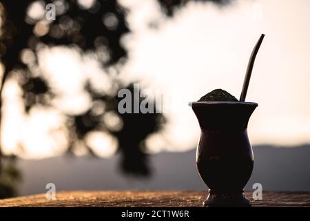 Gaucho Yerba Mate Tee, der chimarão, typisch brasilianisches Getränk, traditionell in einer Cuiade Bombilla Stick Kürbis vor Holzgrund. Rio Grande do Stockfoto