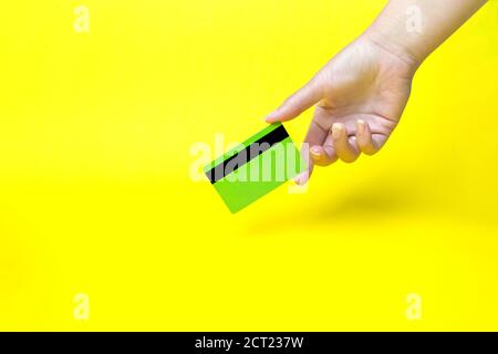 Hand mit Visitenkarte, Mockup, auf gelbem Hintergrund Stockfoto