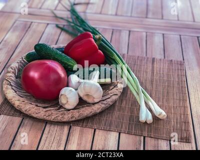 Buntes Stillleben von frischem Bio-Gemüse auf Holzplatte über Holzhintergrund, selektiver Fokus. Gemüseset. Haufen von großer Vielfalt an frischen Stockfoto