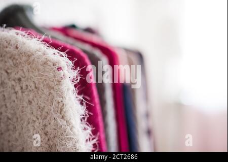 Strickpullover an Kleiderbügeln im offenen Shop in Nahaufnahme. Wintersaison. Stockfoto