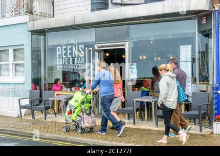 Leute, die an einem nassen Tag in Broadstairs an Peens Cafe & Bar vorbeilaufen. Stockfoto