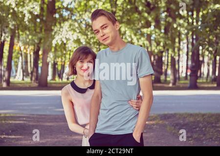 Lächelndes Paar hat ein Date im öffentlichen Park. Junge kaukasische Liebhaber treffen sich im Sommer im Freien. Stockfoto