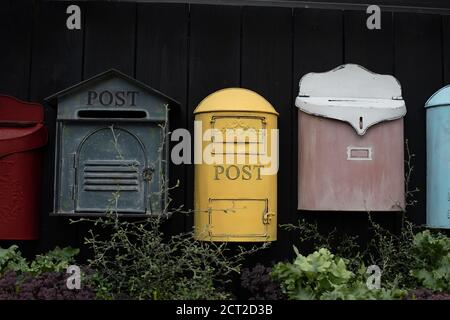 Vintage-Mailbox. Schöne altmodische Briefkästen schwarz gelb rot. Schäbig verwitterte Briefkasten-Set, Hintergrund Stockfoto