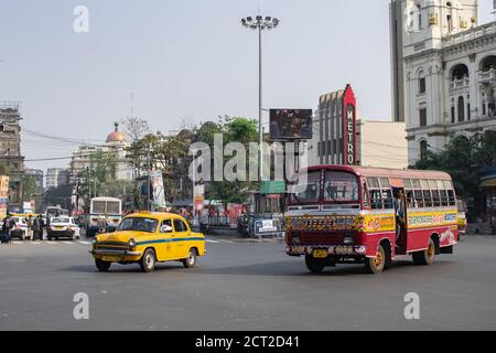 Kolkata, Indien - 1. Februar 2020: Unbekannte Menschen gehen an einer Kreuzung auf der Straßenseite, während Busse und Autos im Verkehr vorbeifahren Stockfoto