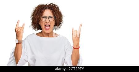 Schöne ältere Frau tragen lässige Kleidung und Brille schreien mit verrückten Ausdruck Rock-Symbol mit Händen nach oben. Musik-Star. Schwer Stockfoto