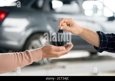 Hand von jungen Reparaturman geben Alarmanlage Fernbedienung Männlicher Kunde Stockfoto