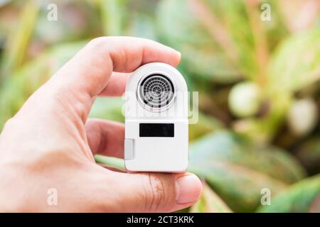 Pranburi, Thailand - 15. September 2020: Ein weißer Xiaomi Xiaoda automatischer Wassersparer auf der Hand mit Baumblättern Hintergrund Stockfoto