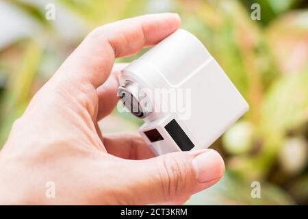 Pranburi, Thailand - 15. September 2020: Ein weißer Xiaomi Xiaoda automatischer Wassersparer auf der Hand mit Baumblättern Hintergrund Stockfoto
