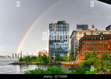 Regenbogen über Wohnhäusern in DUMBO entlang Brooklyn Bridge Park. Stockfoto