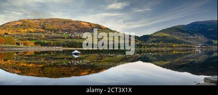 Panorama Boot schwimmt auf dem Wasser, mit einem Berg als Hintergrund, spiegelt das klare und ruhige Wasser wie ein Spiegel in Voss, Norwegen. Stockfoto