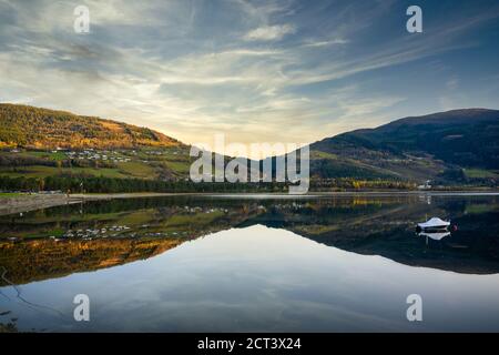 Panorama Boot schwimmt auf dem Wasser, mit einem Berg als Hintergrund, spiegelt das klare und ruhige Wasser wie ein Spiegel in Voss, Norwegen. Stockfoto