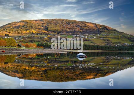 Panorama Boot schwimmt auf dem Wasser, mit einem Berg als Hintergrund, spiegelt das klare und ruhige Wasser wie ein Spiegel in Voss, Norwegen. Stockfoto