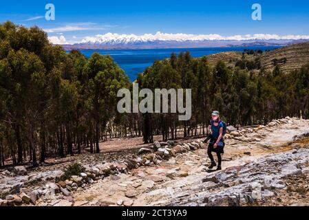 Wandern auf Isla del Sol (Insel der Sonne) mit Cordillera Real Bergkette dahinter, Titicacasee, Bolivien, Südamerika Stockfoto