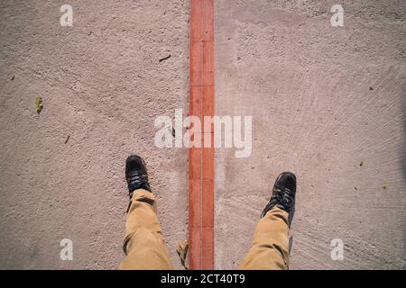 Ein Fuß auf beiden Seiten des Äquators in der "Weltmittelwelt", San Antonio de Pichincha, Quito, Ecuador, Südamerika Stockfoto
