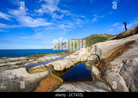 Fotograf auf den Felsen stehend, um ein Foto zu machen, ist Tungeneset ein schöner und beliebter Aussichtspunkt im nationalpark senja im Norden Norwegens. Stockfoto