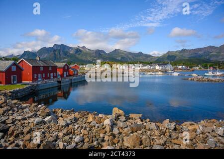 Rote Hütte mit blauem Himmel, der das Wasser am Kabelvaag auf den Lofoten-Inseln im Norden Norwegens reflektiert. Stockfoto