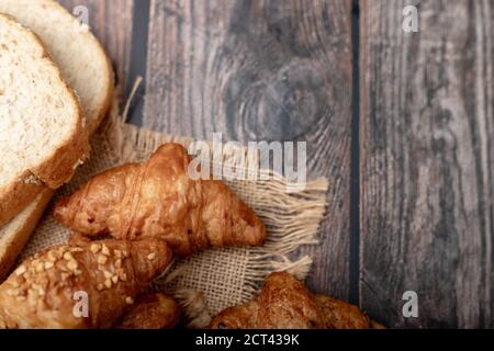 Croissants und Vollkornbrot auf dem Sack mit Holz Tabelle Stockfoto