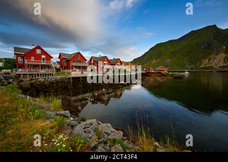 Wunderschönes Haus am Wasser, das den Wasser Abend und den Dämmerungshimmel in ballstad City, lofoten Island im Norden Norwegens reflektiert. Rorbuer ist die Tradition Stockfoto