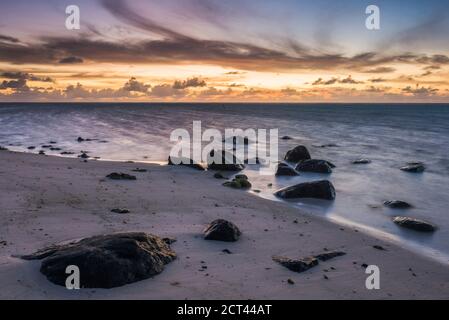 Dramatischer Himmel und tropischer Sonnenaufgang auf einer tropischen Insel im Pazifischen Ozean, am Muri Beach, Rarotonga, Cook Inseln Stockfoto