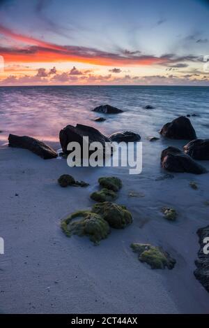 Dramatischer Himmel und tropischer Sonnenaufgang auf einer tropischen Insel im Pazifischen Ozean, am Muri Beach, Rarotonga, Cook Inseln Stockfoto