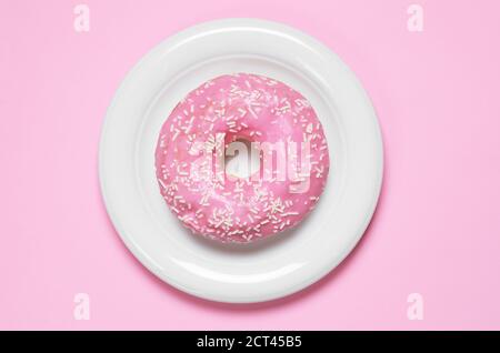 Krapfen mit Puderzucker bedeckt in der Platte, Ansicht von oben. Foto in Pink-farbtönen Stockfoto