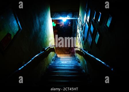 Dramatische Sicht auf die unheimlich Treppen von oben in die Dunkelheit des Inneren des alten Pubs Stockfoto