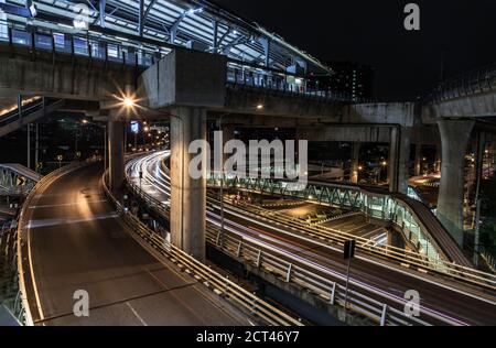 Überführung der Light Trails mit Bangkok City Hintergrund bei Nacht. Schöne Kurven. Selektiver Fokus. Stockfoto