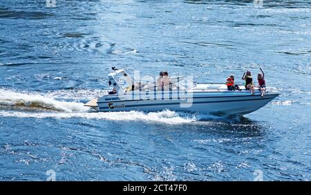 Umea, Norrland Schweden - 16. Juni 2020: Familie fährt Motorboot auf dem Fluss Stockfoto